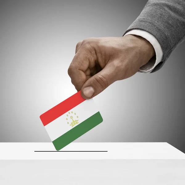 Fekete férfi betöltő flag. Szavazás a koncepció - Tádzsikisztán — Stock Fotó