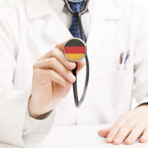 Stetoscopio della holding del medico con la serie delle bandiere - Germania — Foto Stock