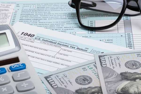 US 1040 Tax Form, calculator, glasses and dollars - studio shot — Stock Photo, Image