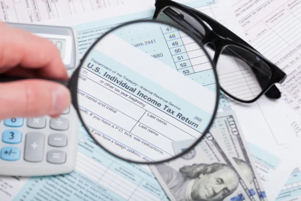 USA 1040 Tax Form 1040 with magnifying glass, glasses, dollars and calculator over it — Stock Photo, Image