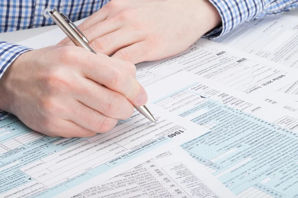 Taxpayer filling out 1040 Tax Form - studio shot — Stock Photo, Image