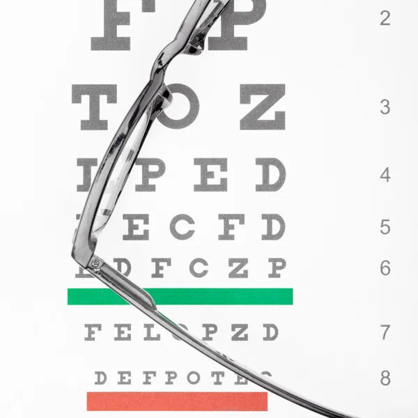 Óculos e tabela de teste de visão — Fotografia de Stock