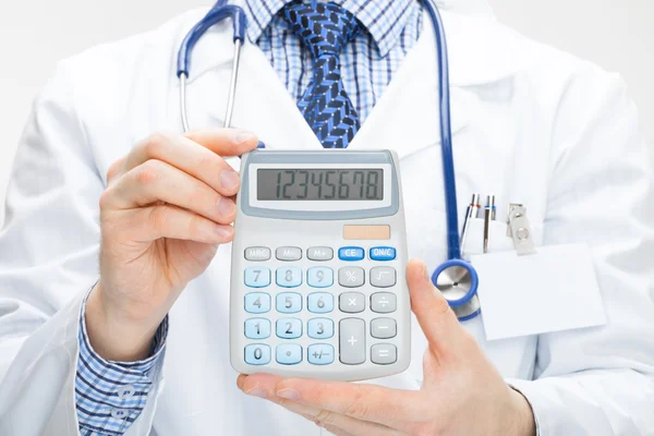 Doctor holding calculator in hands - health care concept - studio shot — Stock Photo, Image