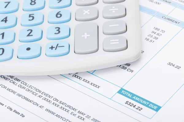 Neat calculator with utility bill under it - studio shot — Stock Photo, Image