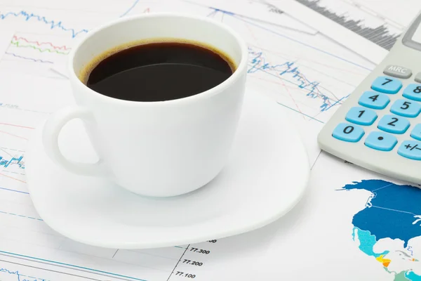 Coffee cup and calculator over world map and some financial charts - business concept — Stock Photo, Image