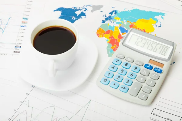 Coffee cup and calculator over world map and some financial charts — Stock Photo, Image