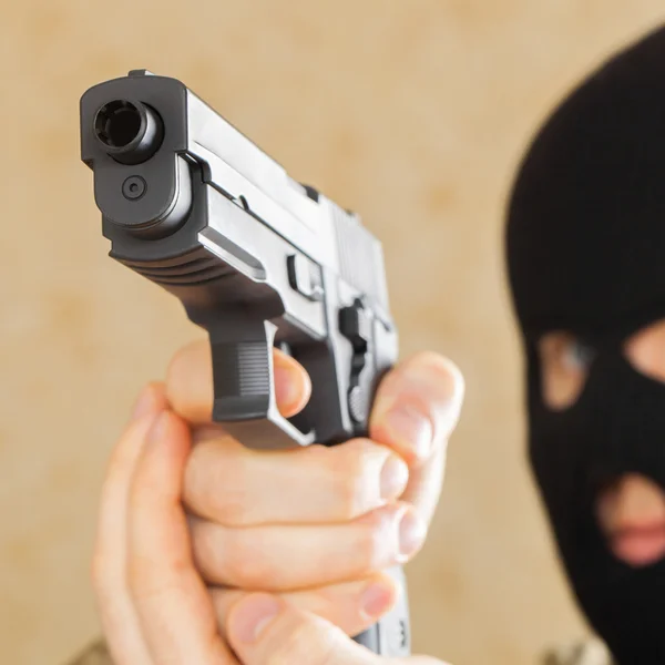 Άνθρωπος στη μαύρη μάσκα κρατώντας όπλο και έτοιμο να το χρησιμοποιήσετε — Φωτογραφία Αρχείου