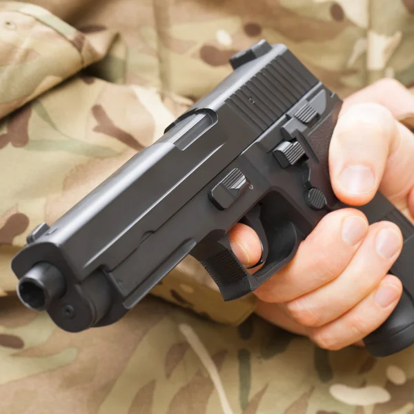 Man in black mask holding gun behind his back — Stok Foto