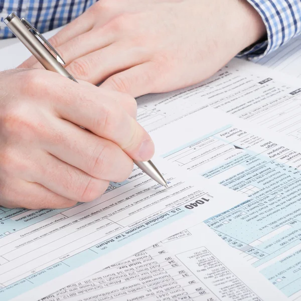 Taxpayer filling out 1040 Tax Form - studio shot — Stock Photo, Image