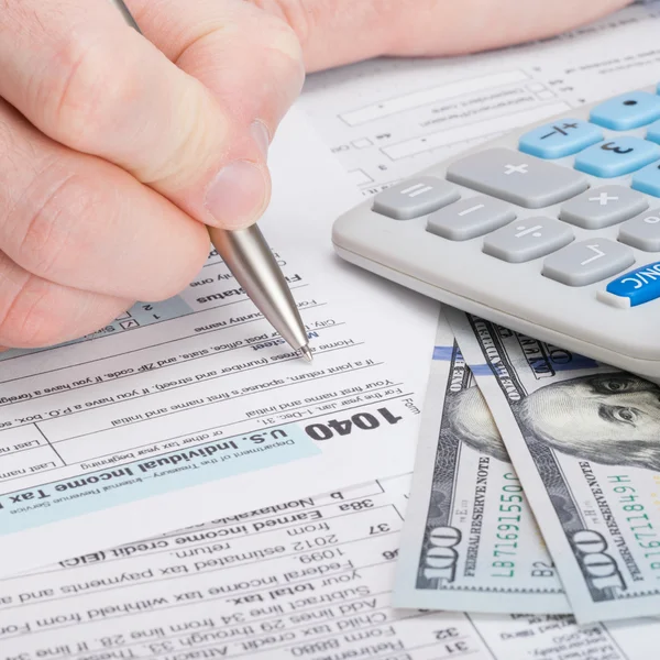 Taxpayer filling out USA 1040 Tax Form - studio shot — Stock Photo, Image