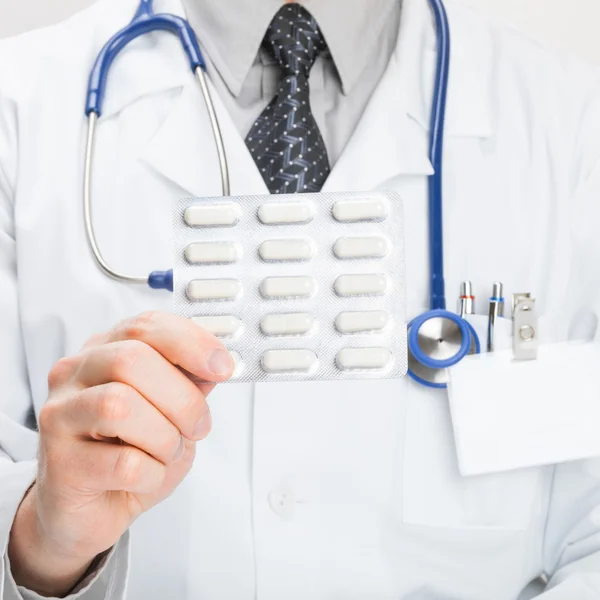 Doctor holdling pills in hand - studio shot — Stock Photo, Image