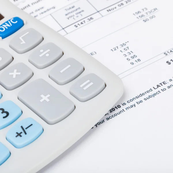 Calculator with utility bill under it - studio shot — Stock Photo, Image