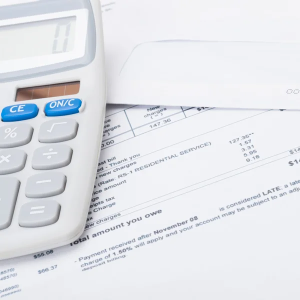 Calculator with utility bill under it - studio shot — Stock Photo, Image