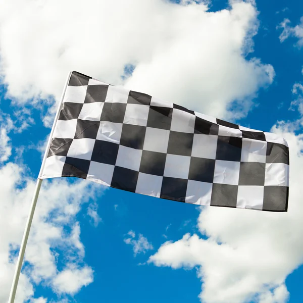 Καρό σημαία κυματίζει στον άνεμο με σύννεφα σε φόντο - ou — Φωτογραφία Αρχείου