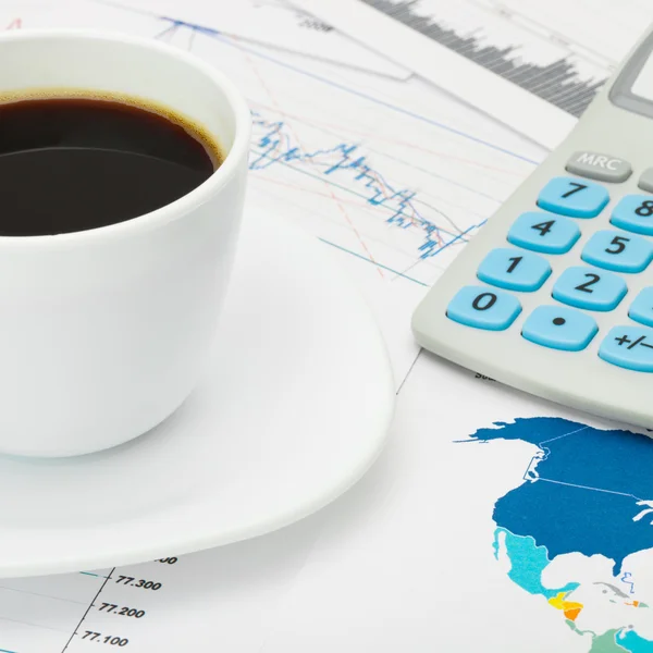 Coffee cup and calculator over world map and some financial char — Stock Photo, Image