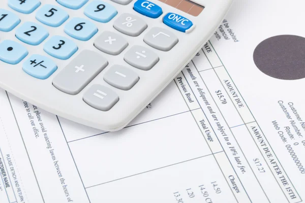 Calculator with monthly utility bill under it — Stock Photo, Image