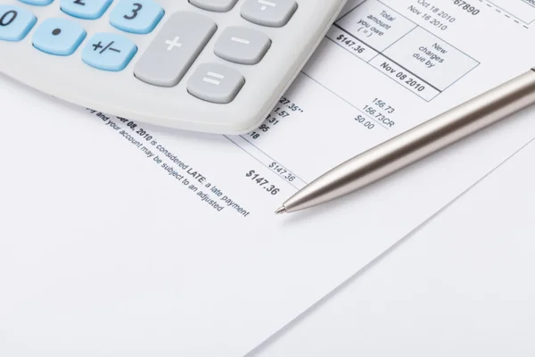 Calculator with silver pen and utility bill under it — Stock Photo, Image