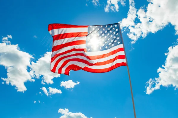 US flag with cumulus clouds and blue sky on background — Stock Photo, Image