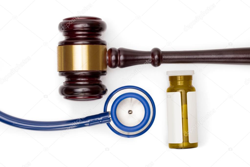 Judge gavel, pills bottle and stethoscope on white backround