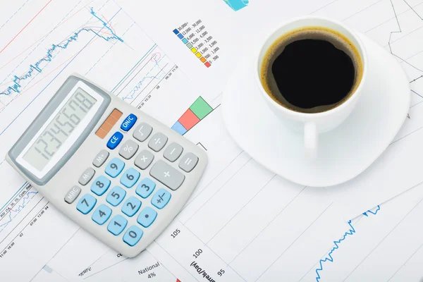 Calculadora sobre mapa del mundo y tablas financieras y taza de café —  Fotos de Stock