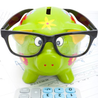 Yeşil piggy banka ve hesap makinesi yanında