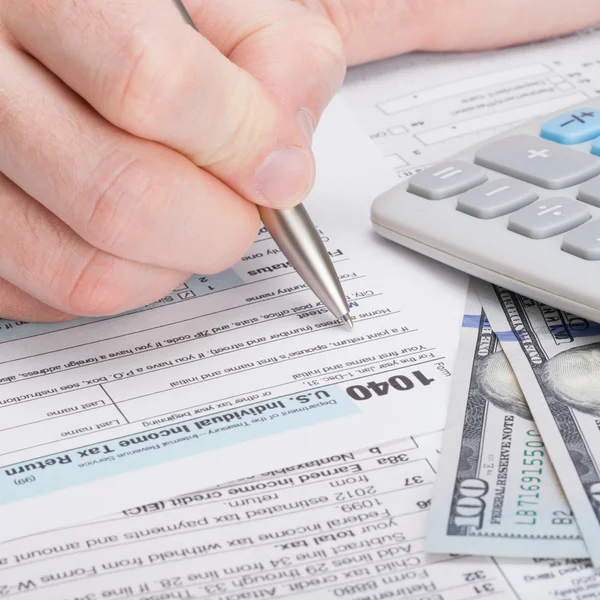 Taxpayer filling out USA 1040 Tax Form - close up studio shot — Stock Photo, Image