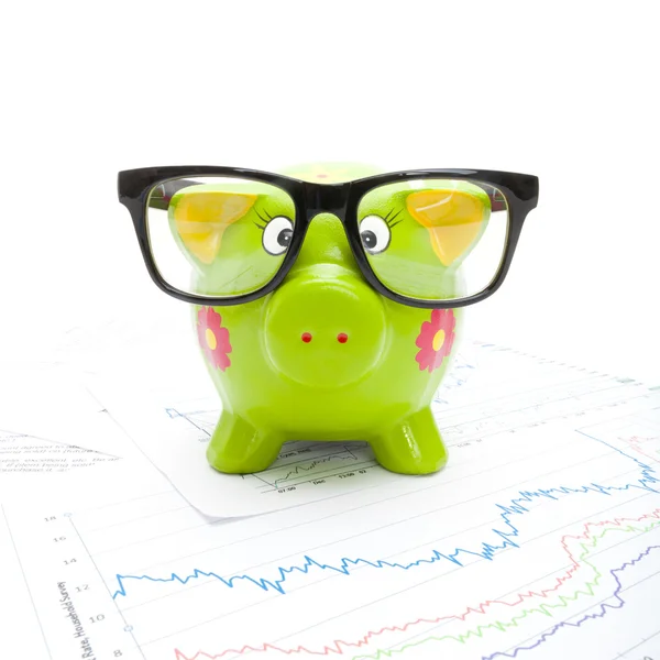 Groene piggy bank over markt charts - studio opname — Stockfoto