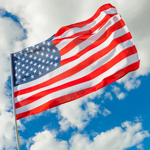 Neat USA flag with cumulus clouds on background - outdoors shot - Stock-foto