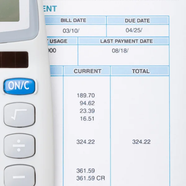 Neat calculator and utility bill next to it - close up shot — Stock Photo, Image