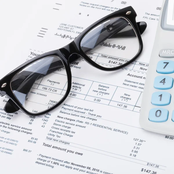 Calculator and glasses with utility bill under it - close up shot — Stock Photo, Image