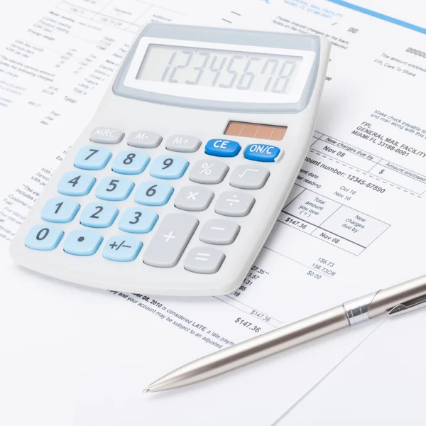 Neat calculator with silver pen and utility bill under it - close up shot — Stock Photo, Image