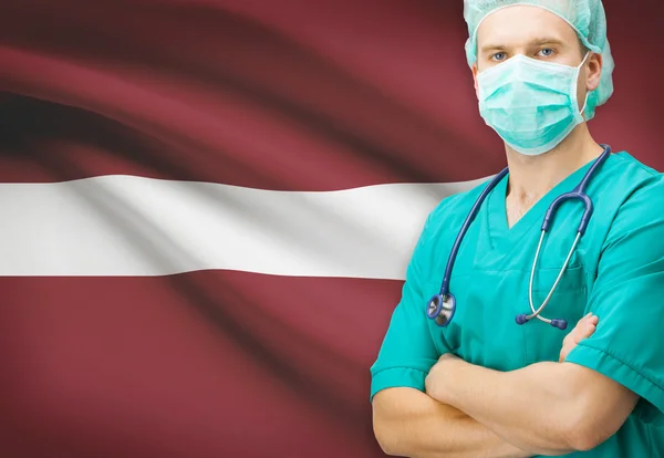Хирург с национальным флагом на фоне серии - Латвия — стоковое фото