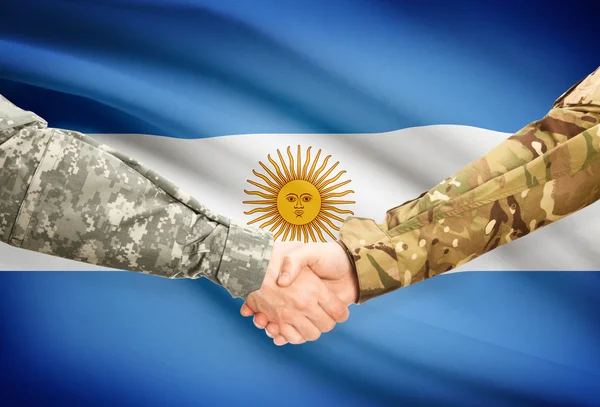 Hommes en uniforme se serrant la main avec le drapeau sur fond - Argentine — Photo