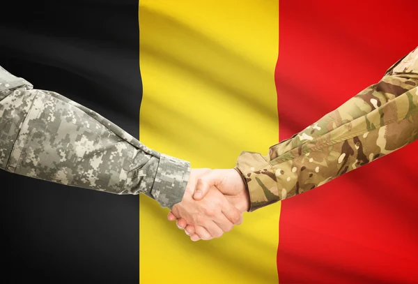 Men in uniform shaking hands with flag on background - Belgium — Stock Photo, Image