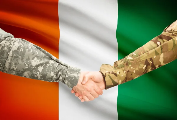 Men in uniform shaking hands with flag on background - Ivory Coast — Stock Photo, Image