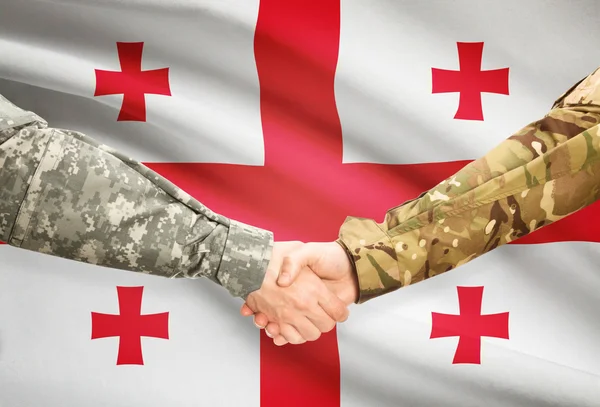 Hommes en uniforme se serrant la main avec le drapeau sur fond - Géorgie — Photo
