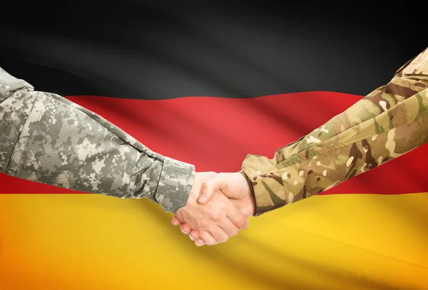 Hommes en uniforme se serrant la main avec le drapeau sur fond - Allemagne — Photo