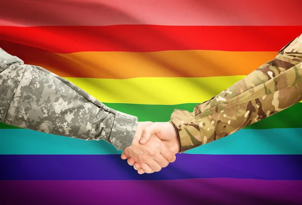 Чоловіки у військовій формі, потискує руку прапор на фоні - ЛГБТ людей — стокове фото