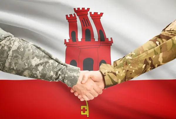 Men in uniform shaking hands with flag on background - Gibraltar — Stock Photo, Image