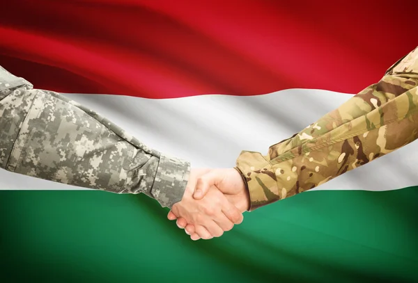 Mannen in uniform schudden handen met vlag op achtergrond - Hongarije — Stockfoto
