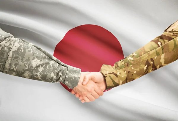 Men in uniform shaking hands with flag on background - Japan — Stok Foto