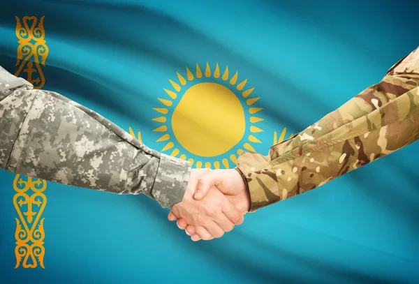 Men in uniform shaking hands with flag on background - Kazakhstan – stockfoto