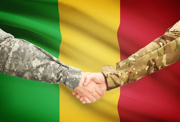 Люди в форме, пожимая руки с флагом на фоне - Мали — стоковое фото