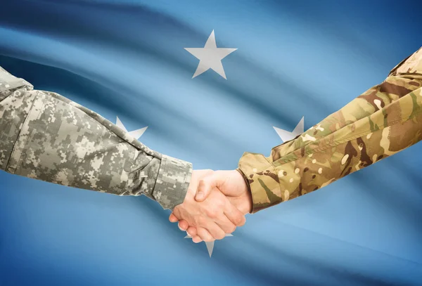 Men in uniform shaking hands with flag on background - Micronesia — Stock Photo, Image