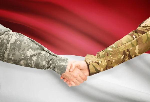 Men in uniform shaking hands with flag on background - Monaco — Stock Photo, Image
