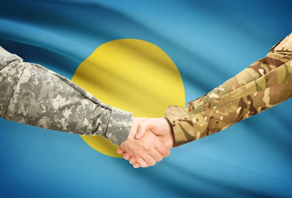 Men in uniform shaking hands with flag on background - Palau — Stock Photo, Image