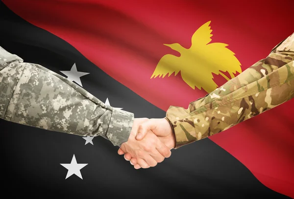Men in uniform shaking hands with flag on background - Papua New Guinea — Stock Photo, Image