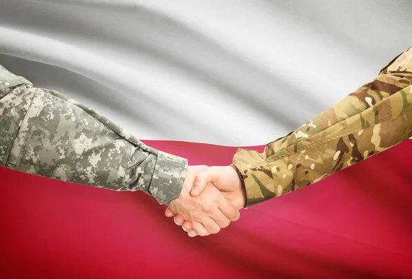 Men in uniform shaking hands with flag on background - Poland — Stock Photo, Image