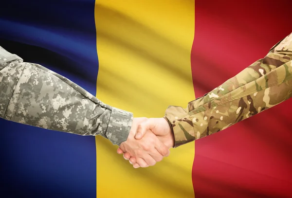 Men in uniform shaking hands with flag on background - Romania — Stock Photo, Image