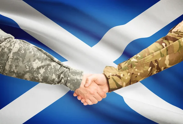 Hombres en uniforme de estrecharme la mano con la bandera en el fondo - Escocia —  Fotos de Stock